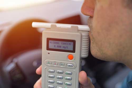 A man blowing into a breathalyzer.