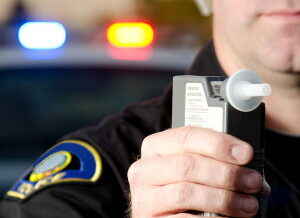 Police officer holding alcotest machine for breath test